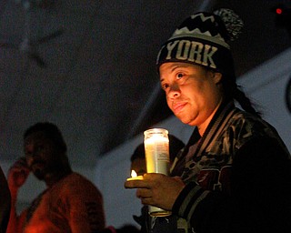 Shirley Martinez, of Youngstown, holds candles while listening to speakers during a vigil for the five children who died in a fire last week at Christ Centered Church on Saturday evening. Martinez said she knows the victims' mother and grandmother from working with them at the Things Remembered warehouse in North Jackson. EMILY MATTHEWS | THE VINDICATOR