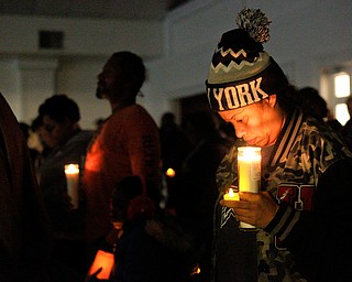 Shirley Martinez, of Youngstown, holds candles while listening to speakers during a vigil for the five children who died in a fire last week at Christ Centered Church on Saturday evening. Martinez said she knows the victims' mother and grandmother from working with them at the Things Remembered warehouse in North Jackson. EMILY MATTHEWS | THE VINDICATOR