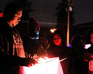 Djuan Kimbrough, of Youngstown, lights and sets off a lantern with his family in honor of the five children who died in a house fire last week after their vigil outside Christ Centered Church on Saturday evening. EMILY MATTHEWS | THE VINDICATOR