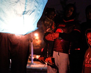 Djuan Kimbrough Jr., 4, of Youngstown, watches with his family as his father, Djuan Kimbrough, lights and sets off a lantern in honor of the five children who died in a house fire last week after their vigil outside Christ Centered Church on Saturday evening. EMILY MATTHEWS | THE VINDICATOR