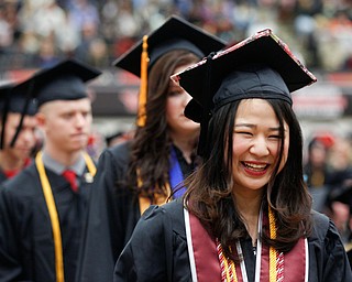 Nami Nagaoka, a foreign exchange student from Japan, smiles as she waits in line to receive her diploma for her Bachelor of Arts from the Cliffe College of Creative Arts and Communication during YSU's commencement ceremony in Beeghly Center on Sunday afternoon. EMILY MATTHEWS | THE VINDICATOR