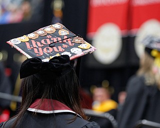 Nami Nagaoka, a foreign exchange student from Japan receiving her Bachelor of Arts from the Cliffe College of Creative Arts and Communication, wears a graduation cap decorated with faces representing the people who helped her on her journey during YSU's commencement ceremony in Beeghly Center on Sunday afternoon. EMILY MATTHEWS | THE VINDICATOR