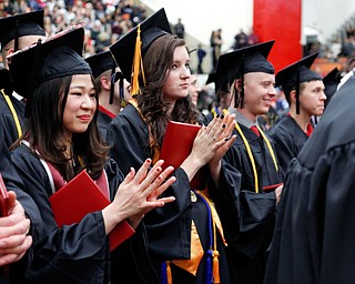 Nami Nagaoka, a foreign exchange student from Japan, claps with her classmates after receiving her diploma for her Bachelor of Arts from the Cliffe College of Creative Arts and Communication during YSU's commencement ceremony in Beeghly Center on Sunday afternoon. EMILY MATTHEWS | THE VINDICATOR