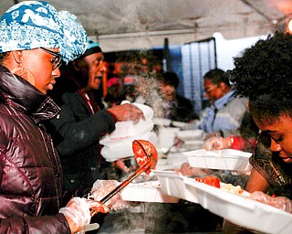 Sarina Chatman, left, and Seannille McAre, both of Youngstown, volunteer at Flambeau's Live's pasta dinner fundraiser to raise money for the funeral of the five fire victims on Tuesday evening. EMILY MATTHEWS | THE VINDICATOR