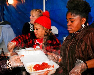 Seannille McAre, right, of Youngstown, and Yvette Kirksey, a teacher at Youngstown City Schools, serve pasta and meatballs at Flambeau's Live's pasta dinner fundraiser to raise money for the funeral of the five fire victims on Tuesday evening. EMILY MATTHEWS | THE VINDICATOR