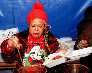 Yvette Kirksey, a teacher at Youngstown City Schools, pours sauce onto past at Flambeau's Live's pasta dinner fundraiser to raise money for the funeral of the five fire victims on Tuesday evening. EMILY MATTHEWS | THE VINDICATOR