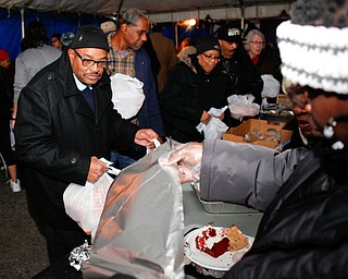 Robert Sims, of Youngstown, receives dessert at Flambeau's Live's pasta dinner fundraiser to raise money for the funeral of the five fire victims on Tuesday evening. EMILY MATTHEWS | THE VINDICATOR