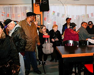 People wait inside Flambeau's Live to buy a pasta dinner during a fundraiser to raise money for the funeral of the five fire victims on Tuesday evening. EMILY MATTHEWS | THE VINDICATOR