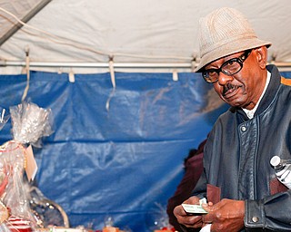 Ernest Riggins, of Youngstown, looks at raffle baskets at Flambeau's Live's fundraiser for the funeral of the five fire victims on Tuesday evening. EMILY MATTHEWS | THE VINDICATOR