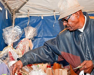 Ernest Riggins, of Youngstown, looks at raffle baskets at Flambeau's Live's fundraiser for the funeral of the five fire victims on Tuesday evening. EMILY MATTHEWS | THE VINDICATOR