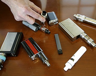 In this April 10, 2018, file photo, a high school principal displays vaping devices that were confiscated from students in such places as restrooms or hallways at the school in Massachusetts. The U.S. surgeon general says swift action is needed to prevent millions of teenagers and adolescents from becoming hooked on Juul and other high-nicotine electronic cigarettes. Surgeon General Jerome Adams said Tuesday, Dec. 18, that parents, teachers and physicians must take aggressive steps to address an epidemic of underage vaping. 