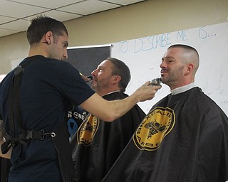 Neighbors | Jessica Harker .Twenty-seven men volunteered to have their facial hair shaved on Nov. 29 at Austintown Fitch's cafeteria for the school's first Shave Off event, organized by Man Up Mahoning Valley, an organization that raises awareness for prostate cancer.