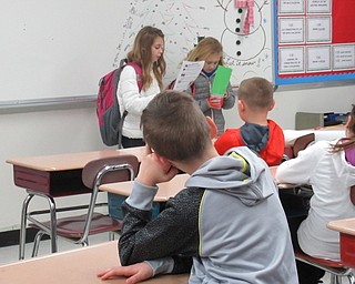 Neighbors | Jessica Harker.Students Delaney Demetrios and Halle Argiro read instructions to a Poland classroom about how to recieve bucket filler coupons.