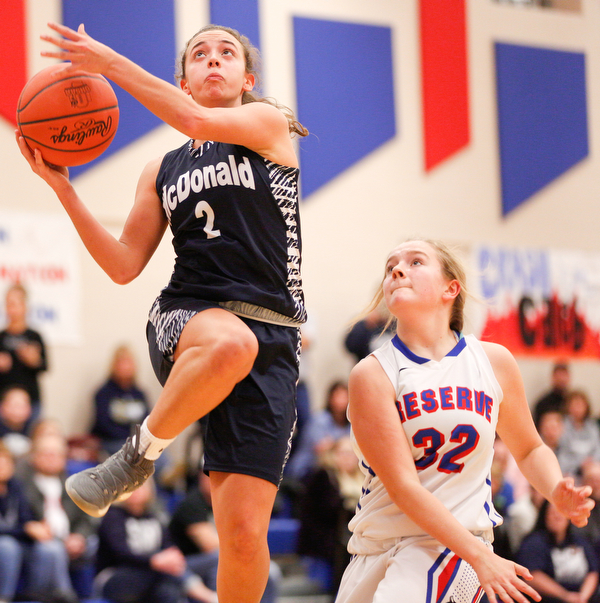 McDonald's Olivia Perry jumps to make a shot while Western Reserve's Alyssa Serensky tries to block during their game at Western Reserve on Thursday night. EMILY MATTHEWS | THE VINDICATOR