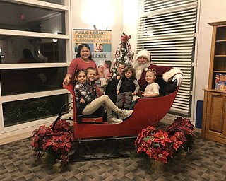 Neighbors | Jessica Harker.From left, Destiney, Mackenzie and Adien Paredes, Jakobie and Jocelynn Chapdelaine, and Logan Maxwell posed with Santa Claus at the Austintown library on Dec. 10.