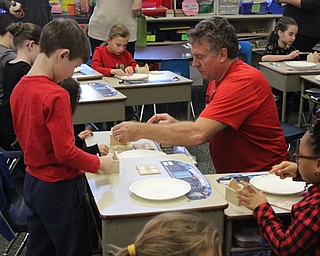 Neighbors | Abby Slanker.Former Canfield School Board member Barry Tancer instructed C.H. Campbell Elementary School second-grade students in Stephanie Maurer’s class on how to build mini wooden gingerbread house ornaments using math skills on Dec. 13.