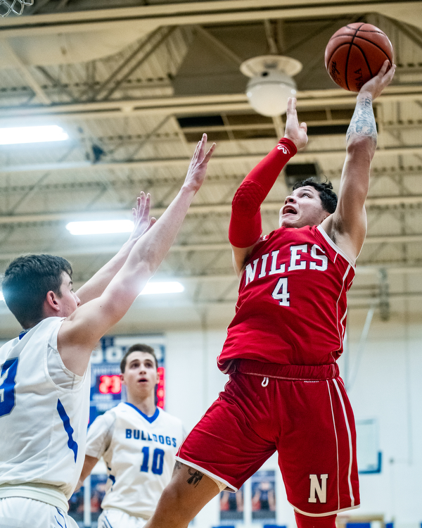 DIANNA OATRIDGE | THE VINDICATOR Niles' Cyler Kane-Johnson (4) shoots over Lakeview's Carter Huff (left) during the Bulldogs' 68-41 victory in Cortland on Friday.