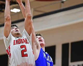 GIRARD, OHIO - DECEMBER 21, 2018: Girard's Austin Claussell and Poland's Colin Todd jump for a rebound during the first half of their game, Friday night at Girard High School. DAVID DERMER | THE VINDICATOR