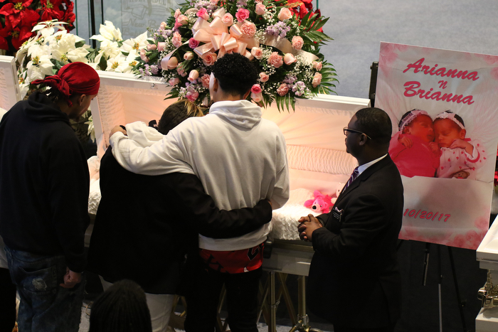      ROBERT  K. YOSAY | THE VINDICATOR.. Services for the five children killed Dec. 9 in a fire at their Parkcliffe Avenue home were held at New Bethel Baptist Church....Relatives hug as they say their goodbyes to the children