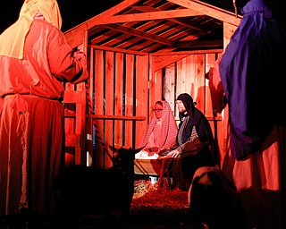 Mary, portrayed by Rachael Lanham, Joseph, portrayed by Brice Harris, kneel beside their baby Jesus during the Live Nativity at Zion Lutheran Church in Cornersburg on Sunday evening. EMILY MATTHEWS | THE VINDICATOR