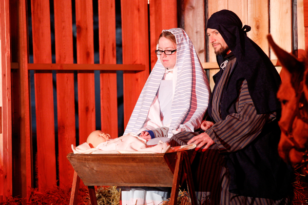 Mary, portrayed by Rachael Lanham, Joseph, portrayed by Brice Harris, kneel beside their baby Jesus while Fancy Pants the donkey, from Felger Exotics, watches them during the Live Nativity at Zion Lutheran Church in Cornersburg on Sunday evening. EMILY MATTHEWS | THE VINDICATOR