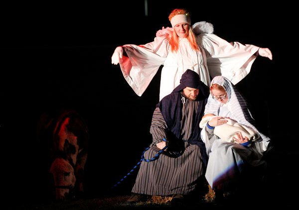 Mary, portrayed by Rachael Lanham, holds Jesus, while Joseph, portrayed by Brice Harris, sits beside her and an angel, portrayed by Janelle Nagy, stands behind them during the Live Nativity at Zion Lutheran Church in Cornersburg on Sunday evening. EMILY MATTHEWS | THE VINDICATOR