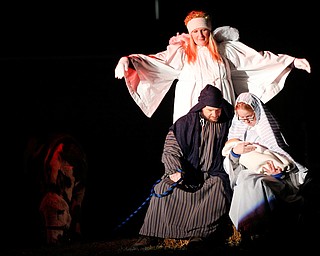 Mary, portrayed by Rachael Lanham, holds Jesus, while Joseph, portrayed by Brice Harris, sits beside her and an angel, portrayed by Janelle Nagy, stands behind them during the Live Nativity at Zion Lutheran Church in Cornersburg on Sunday evening. EMILY MATTHEWS | THE VINDICATOR