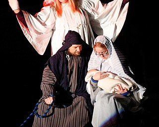 Mary, portrayed by Rachael Lanham, holds Jesus, while Joseph, portrayed by Brice Harris, sits beside her and an angel, portrayed by Janelle Nagy, stands behind them during the Live Nativity at Zion Lutheran Church in Cornersburg on Sunday evening. EMILY MATTHEWS | THE VINDICATOR