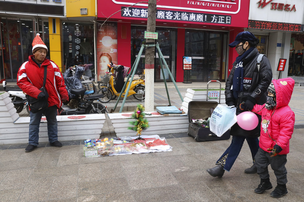 In this Saturday, Dec. 22, 2018, photo, a man sells Christmas decorations on a street of Zhangjiakou in northern China's Hebei province. At least four Chinese cities and one county have restricted Christmas celebrations this year. Churches in another city have been warned to keep minors away from Christmas, and at least ten schools nationwide have curtailed Christmas on campus, The Associated Press has found.