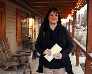 In this Thursday, Dec. 20, 2018 photo, Reagen Adair holds a RIP Medical Debt yellow envelope at her home in Murchison, Texas. The co-founders of RIP Medical Debt buy millions of dollars in past-due medical debt for pennies on the dollar. But instead of hounding people to pay, they send letters saying the debt is erased, no strings attached.