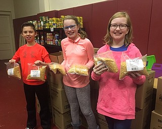 Neighbors | Submitted.Boardman Center Intermediate School fifth-graders Ryan Vodhanel (left), Julia Forbes and Mady Kiser show off bags of split peas in the school food pantry. Each made a different recipe with split peas.