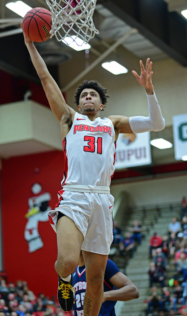 YOUNGSTOWN, OHIO - DECEMBER 28, 2018: Michael Akuchie flies through the air before dunking the basketball during the first half of their game, Saturday afternoon at Beeghly Center. Detroit Mercy won 78-66. DAVID DERMER | THE VINDICATOR