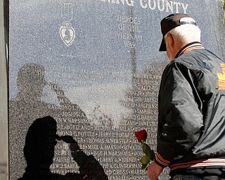 A veteran salutes before placing a rose at the foot of the Vietnam Veterans Memorial in honor of fallen soldiers during the annual Laying of the Roses ceremony in Youngstown on Sunday. EMILY MATTHEWS | THE VINDICATOR