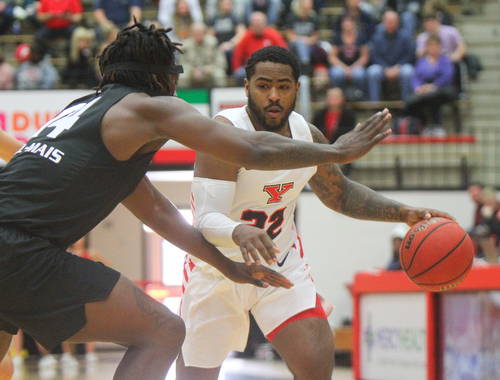 William D. Lewis The Vindicator  YSU'sDevin Morgan(22) drives around Oakland's Xavier Hill-Mais(14) during 12-302018 action at YSU.