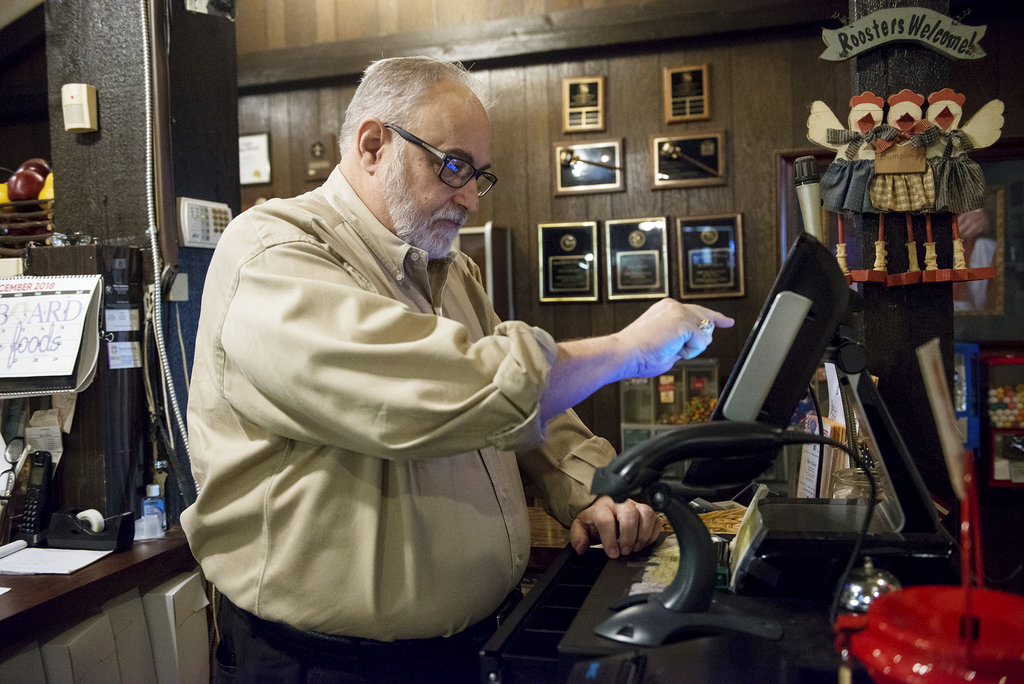 In this Tuesday, Dec. 18, 2018, photo, Mike Wiggins, owner of Granny Shaffer's, works at the restaurant in Joplin, Mo. Wages will be increasing for millions of low-income workers across the U.S. as the new year ushers in new laws in numerous states. In Missouri and Arkansas, minimum wages are rising as a result of voter-approved ballot initiatives.