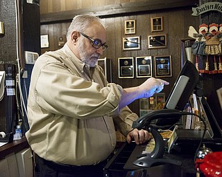 In this Tuesday, Dec. 18, 2018, photo, Mike Wiggins, owner of Granny Shaffer's, works at the restaurant in Joplin, Mo. Wages will be increasing for millions of low-income workers across the U.S. as the new year ushers in new laws in numerous states. In Missouri and Arkansas, minimum wages are rising as a result of voter-approved ballot initiatives.