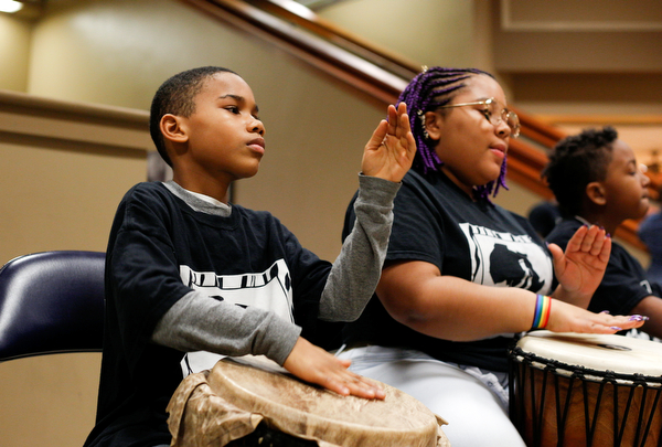 Jumane McKinney, 10, of Cleveland, left, and Effie Dawson, 14, of Liberty, drum with Harambee inside 20 Federal Place during First Night Youngstown Monday night. EMILY MATTHEWS | THE VINDICATOR