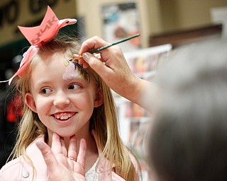 Isabella Shook, 8, of Canfield, gets her face painted by Gloria Siegfried, with The Laughing Ladybug, inside 20 Federal Place during First Night Youngstown Monday night. EMILY MATTHEWS | THE VINDICATOR