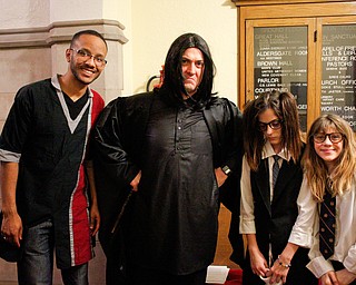 From left, Pastor Dawan Buie, Joshua Reichard, dressed as Snape, Maria Reichard, 13, dressed as Moaning Myrtle, and Olivia Reichard, 10, dressed as Luna Lovegood, pose for a photo at the Harry Potter Experience inside Trinity United Methodist Church during First Night Youngstown Monday night. EMILY MATTHEWS | THE VINDICATOR