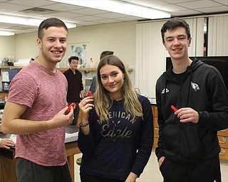 Neighbors | Abby Slanker.Canfield High School juniors, from left, Mario Mavar, Emily Riley-Gomez and Brayden Beck showed off their finished products of Variegated Disaccharide “J” Tubes, also known as candy canes, after following a scientific recipe in Tom Slaven’s chemistry class.