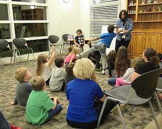 Neighbors | Jessica Harker.Librarian Mary Yee read stories to children during the Imagine With Us program at the Austintown branch Dec. 12.