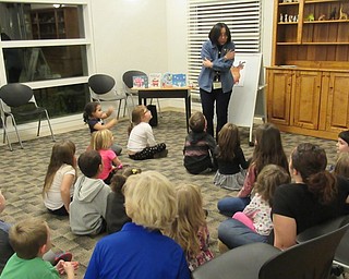 Neighbors | Jessica Harker.Children seperated from their parents where librarian Mary Lee sang songs and played games with them on Dec. 12 at the Austintown library's Imagine With Us program.