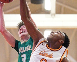 Ursuline's Pat McLaughlin catches a rebound as Cardinal Mooney's Terrell Brown reaches for it during their game at Cardinal Mooney on Friday night. EMILY MATTHEWS | THE VINDICATOR