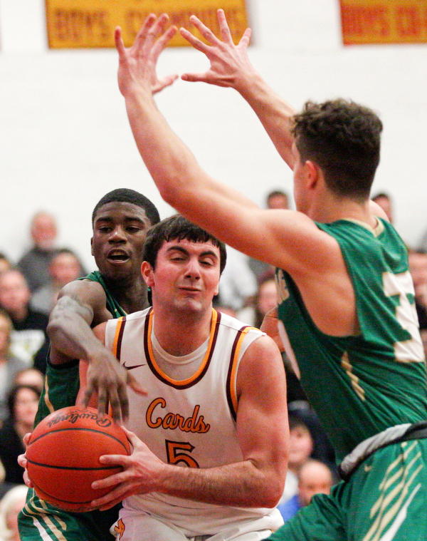 Ursuline's RJ Clark reaches from behind Cardinal Mooney's Pete Haas to hit the ball out of his hands while Ursuline's Luke Pipala tries to block in front of Haas during their game at Cardinal Mooney on Friday night. EMILY MATTHEWS | THE VINDICATOR