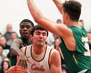 Ursuline's RJ Clark reaches from behind Cardinal Mooney's Pete Haas to hit the ball out of his hands while Ursuline's Luke Pipala tries to block in front of Haas during their game at Cardinal Mooney on Friday night. EMILY MATTHEWS | THE VINDICATOR