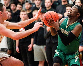 Ursuline's RJ Clark looks to pass the ball as Cardinal Mooney's John Murphy tries to block him during their game at Cardinal Mooney on Friday night. EMILY MATTHEWS | THE VINDICATOR