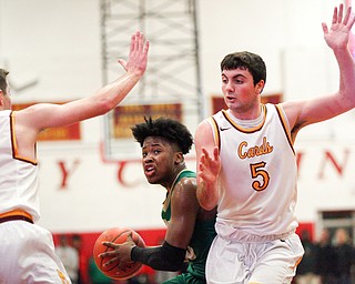 Ursuline's Travis Easterly looks to pass the ball as Cardinal Mooney's Pete Haas, right, and Anthony Fire try to block him during their game at Cardinal Mooney on Friday night. EMILY MATTHEWS | THE VINDICATOR