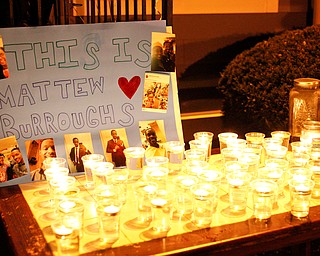 A poster a candles for Matthew Burroughs are displayed at a vigil for him outside of his Royal Mall Apartment on Saturday night. EMILY MATTHEWS | THE VINDICATOR