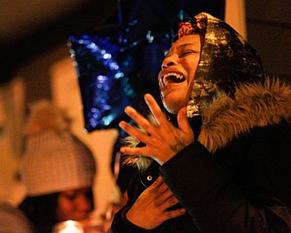 Tara Elkins, the girlfriend of Matthew Burroughs, sings His Eye is on the Sparrow, a song she said Burroughs liked, at a vigil for Burroughs outside of his Royal Mall Apartment on Saturday night. EMILY MATTHEWS | THE VINDICATOR