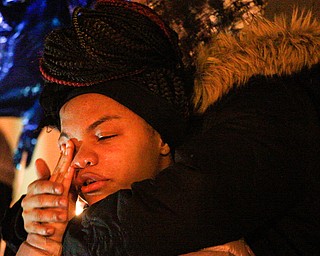 Ashantee Allen, 15, of Warren, speaks about her relationship with Matthew Burroughs as well as how she will miss seeing how happy Burroughs made her mom, Tara Elkins, who is hugging her, at a vigil for Burroughs outside of his Royal Mall Apartment on Saturday night. EMILY MATTHEWS | THE VINDICATOR